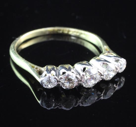 An 18ct gold and platinum five stone graduated diamond ring, size O.